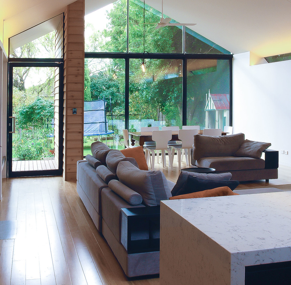 Ejemplo de salón abierto contemporáneo de tamaño medio con paredes blancas, suelo de bambú y suelo beige