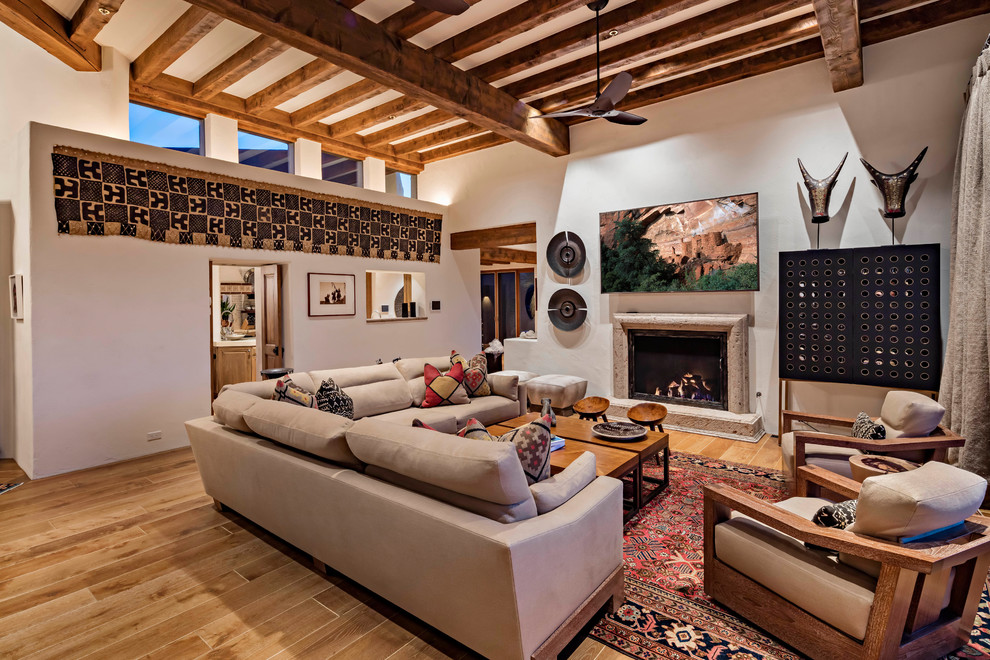 Southwest medium tone wood floor and brown floor living room photo in Phoenix with white walls and a standard fireplace