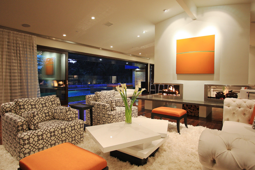 Photo of a modern living room curtain in Los Angeles with a two-sided fireplace.