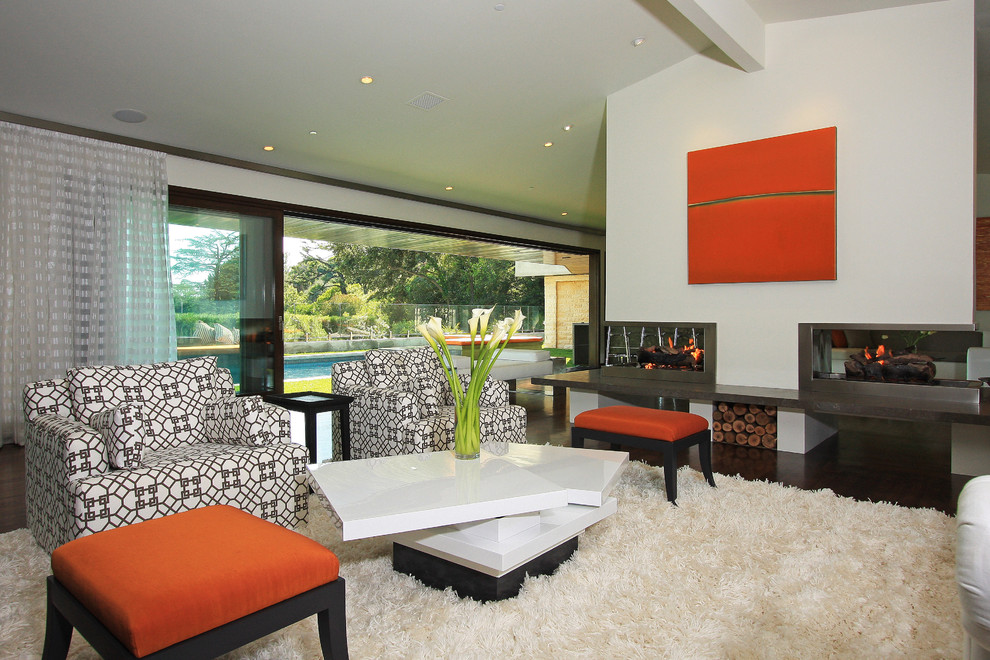 Foto de salón minimalista con chimenea de doble cara y cortinas