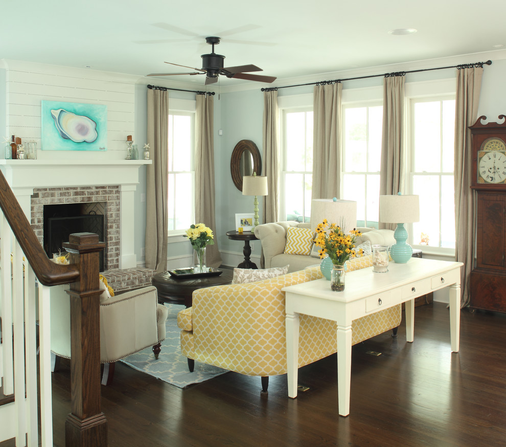 Beach style dark wood floor living room photo in Charleston with blue walls, a standard fireplace and a brick fireplace
