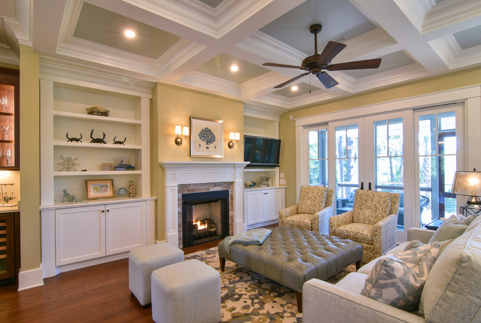 Cette photo montre un grand salon chic ouvert avec un mur beige, un sol en bois brun, une cheminée standard et un manteau de cheminée en carrelage.