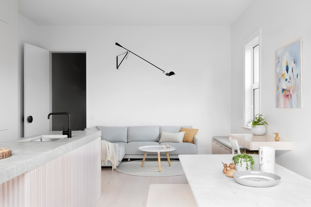 Scandinavian open plan living room in Melbourne with white walls and light hardwood flooring.