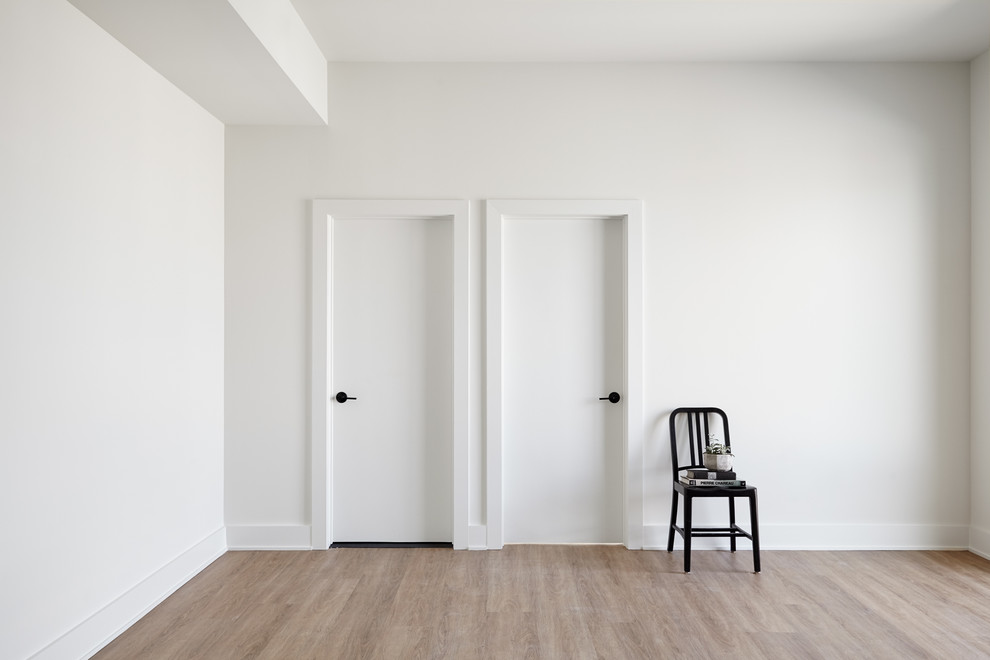 Immagine di un piccolo soggiorno design chiuso con pareti bianche, parquet chiaro, nessun camino, nessuna TV e pavimento beige