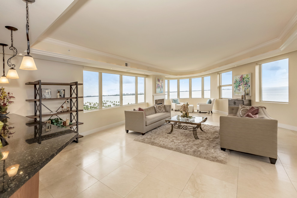 Großes, Offenes Modernes Wohnzimmer mit beiger Wandfarbe, Travertin, Kamin, Kaminumrandung aus Stein und beigem Boden in Tampa