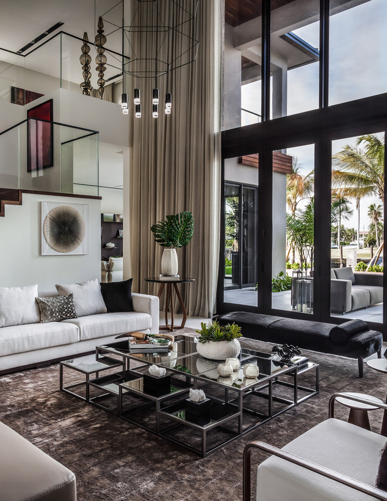Expansive contemporary open plan living room in Miami with grey walls, porcelain flooring, no fireplace, no tv and grey floors.