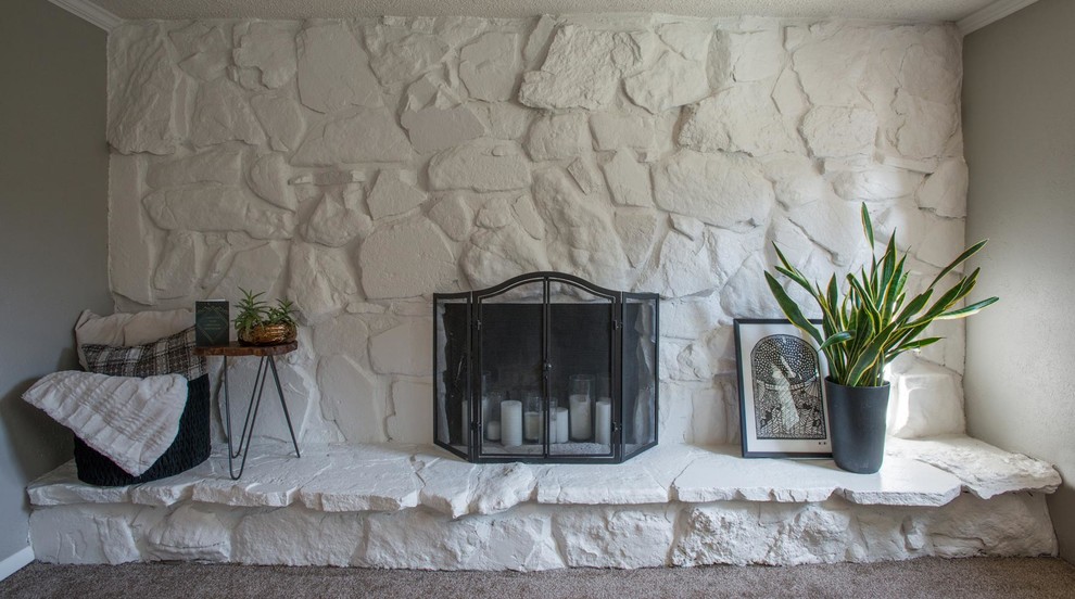 デンバーにある高級な中くらいなトラディショナルスタイルのおしゃれなリビング (マルチカラーの壁、カーペット敷き、標準型暖炉、石材の暖炉まわり、テレビなし、ベージュの床) の写真