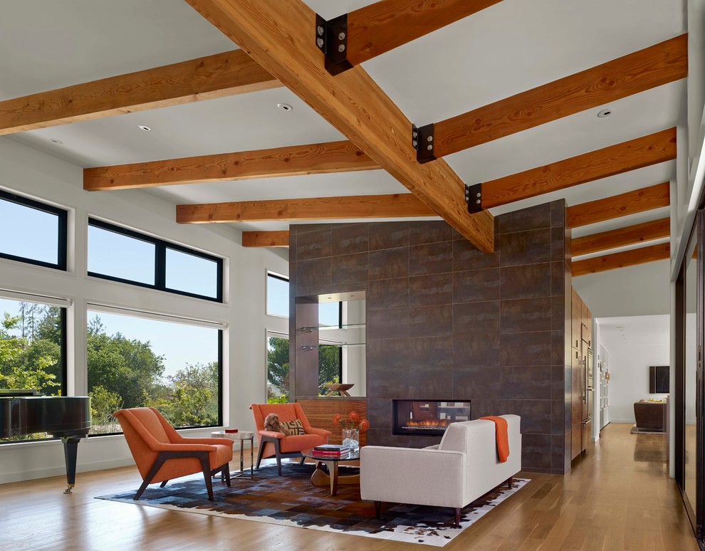 Inspiration pour un grand salon design ouvert avec une salle de réception, un sol en bois brun, une cheminée ribbon et un manteau de cheminée en carrelage.