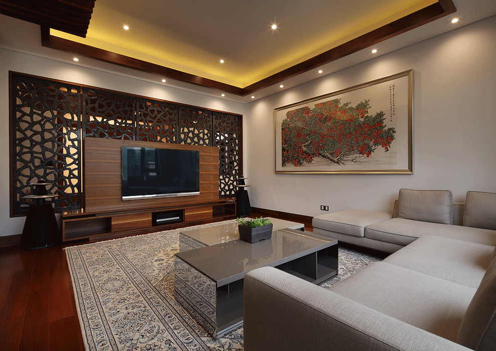 Modernes Wohnzimmer mit grauer Wandfarbe, dunklem Holzboden und TV-Wand in Sonstige