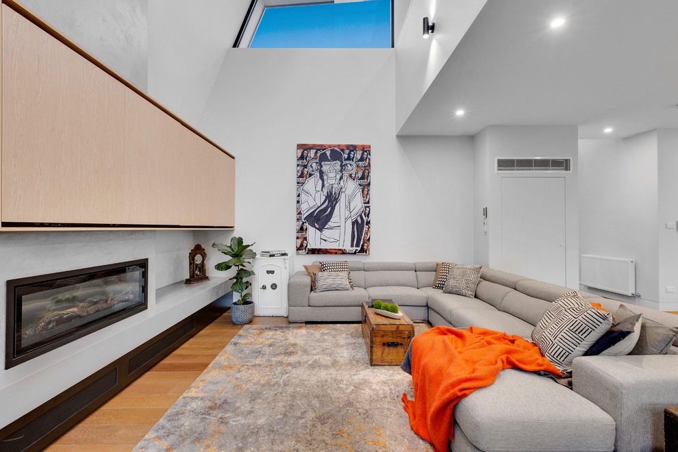Mittelgroßes, Offenes Modernes Wohnzimmer mit weißer Wandfarbe, Gaskamin, Kaminumrandung aus Metall, braunem Holzboden, verstecktem TV und braunem Boden in Melbourne