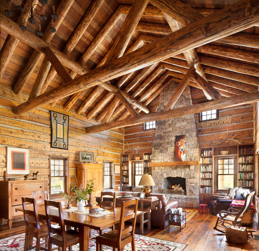 Large rustic formal open plan living room in Other with dark hardwood flooring, a standard fireplace, a stone fireplace surround, brown floors and feature lighting.