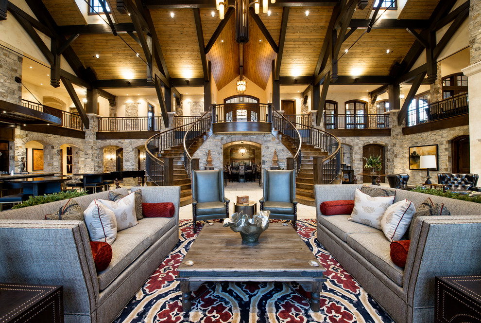 This is an example of an expansive rustic formal open plan living room in Denver with a wall mounted tv, white walls, limestone flooring, a standard fireplace, a stone fireplace surround and white floors.