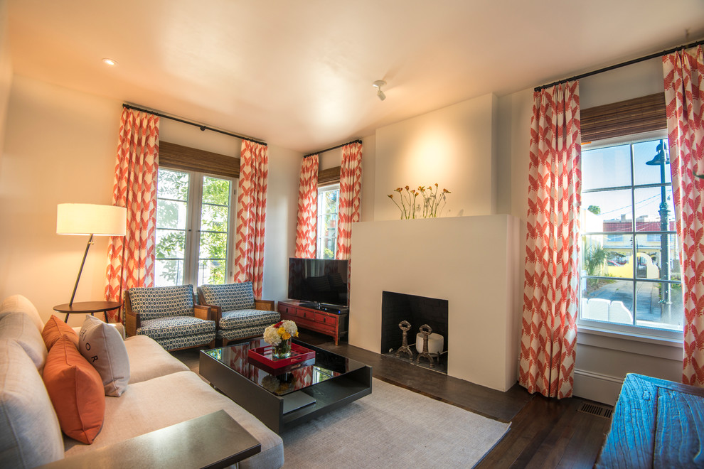 Inspiration pour un petit salon design fermé avec un sol en bois brun, une cheminée standard, un manteau de cheminée en plâtre, un téléviseur indépendant, un sol marron et un mur beige.
