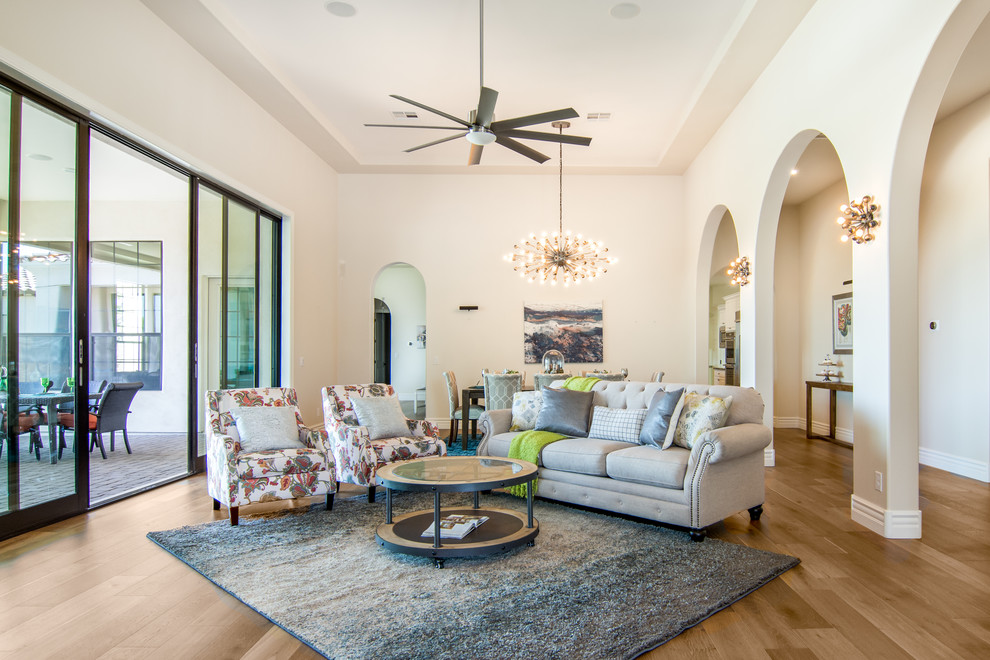 Immagine di un soggiorno chic con pareti bianche, pavimento in legno massello medio e pavimento marrone