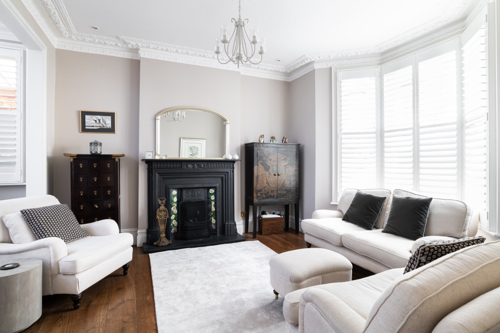 Traditional living room in London with grey walls, dark hardwood flooring, a standard fireplace, brown floors and a chimney breast.