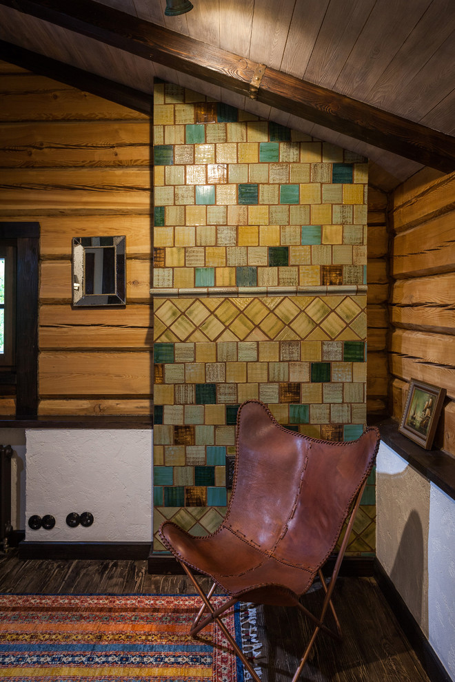 Modelo de salón rústico con paredes beige, suelo de madera oscura y todas las chimeneas