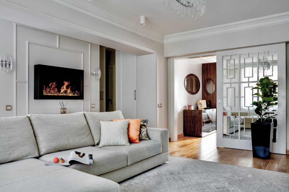 Aménagement d'un petit salon classique ouvert avec un sol en bois brun, cheminée suspendue, un manteau de cheminée en métal, un sol beige et un mur blanc.