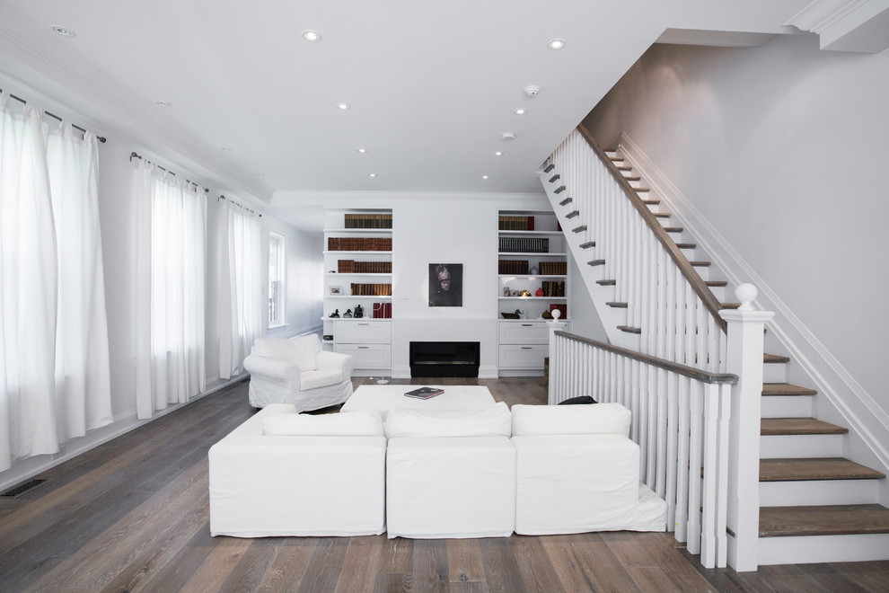 Medium sized traditional open plan living room in Toronto with white walls, medium hardwood flooring, a ribbon fireplace, no tv and a plastered fireplace surround.