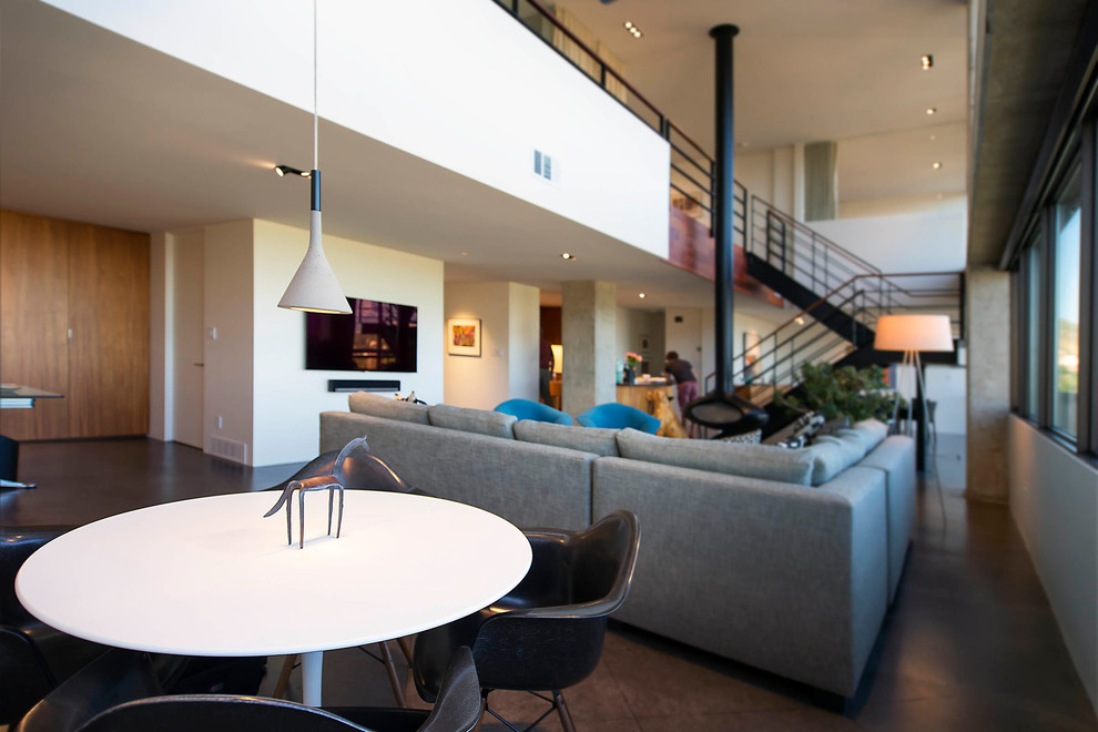 Foto di un ampio soggiorno minimalista stile loft con pareti bianche, pavimento in cemento, camino sospeso, TV a parete e pavimento grigio