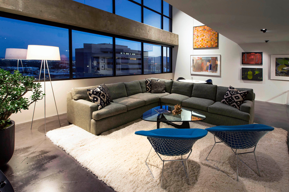 Источник вдохновения для домашнего уюта: огромная двухуровневая гостиная комната в стиле модернизм с белыми стенами, бетонным полом, подвесным камином, телевизором на стене и серым полом