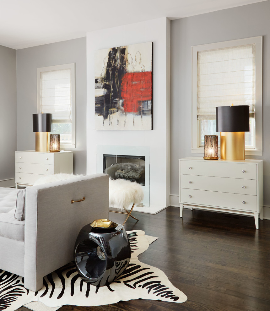 Immagine di un soggiorno design con pareti grigie, parquet scuro e camino classico