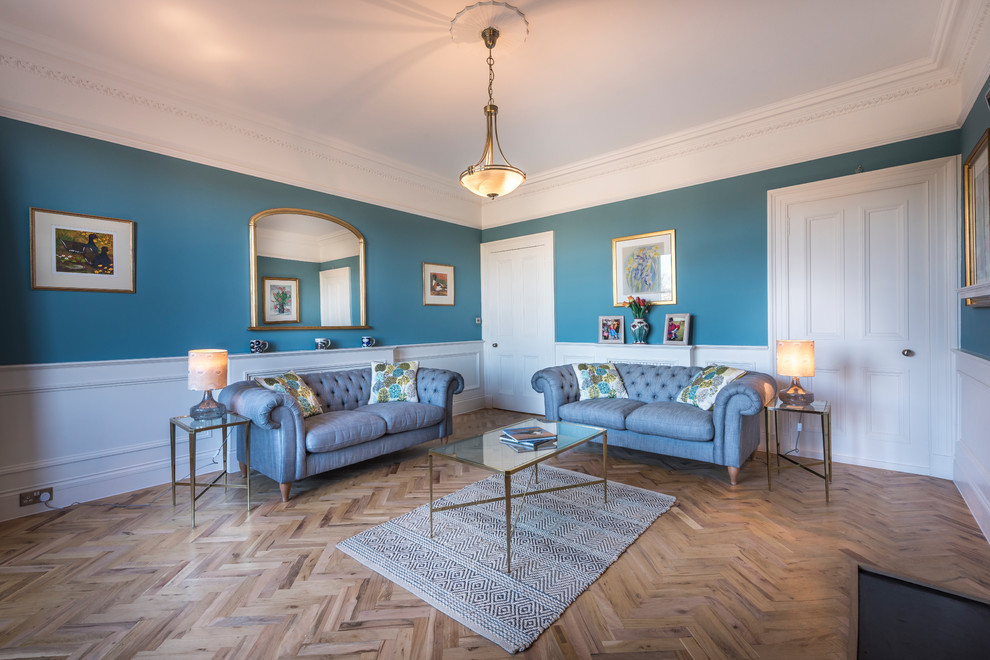 Imagen de salón cerrado clásico con paredes azules, suelo de madera en tonos medios y suelo marrón
