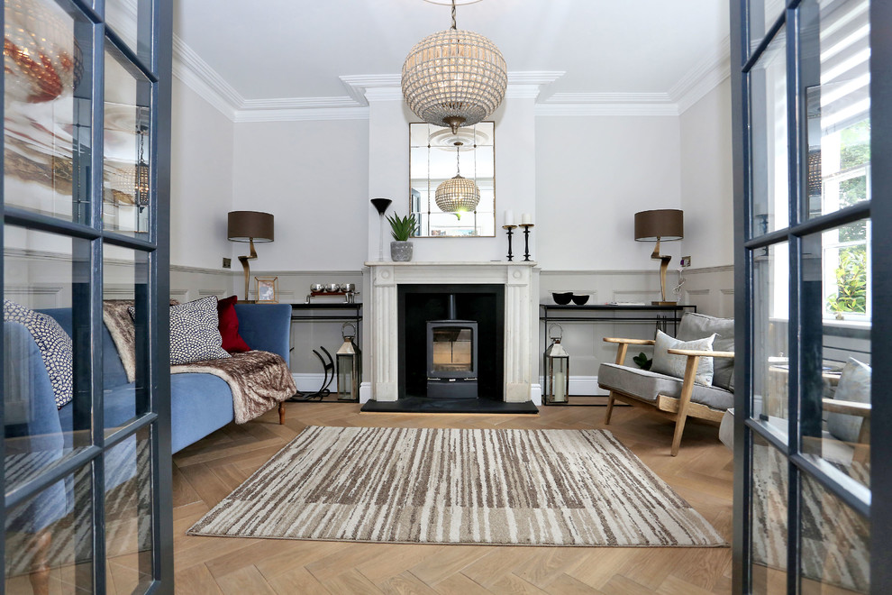 Klassisches Wohnzimmer mit weißer Wandfarbe, hellem Holzboden, Kamin und beigem Boden in London