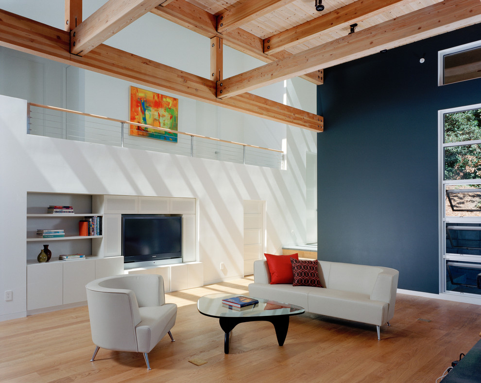 На фото: открытая гостиная комната среднего размера в стиле модернизм с синими стенами, мультимедийным центром, светлым паркетным полом и акцентной стеной