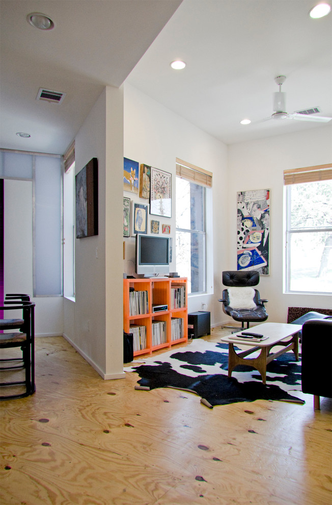 Idee per un piccolo soggiorno minimal aperto con libreria, pareti bianche, pavimento in compensato e TV autoportante