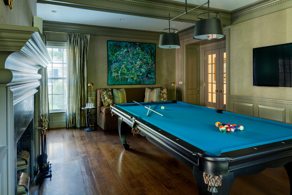 Стильный дизайн: большая изолированная гостиная комната в классическом стиле с зелеными стенами, темным паркетным полом, стандартным камином, фасадом камина из камня и телевизором на стене - последний тренд