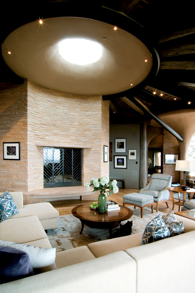 Aménagement d'un très grand salon sud-ouest américain ouvert avec parquet en bambou, une cheminée standard et un manteau de cheminée en pierre.
