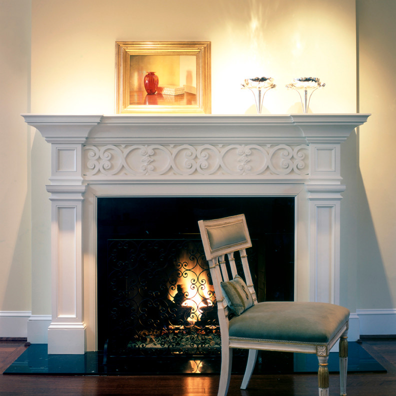 Elegant medium tone wood floor living room photo in DC Metro with white walls, a standard fireplace and a wood fireplace surround