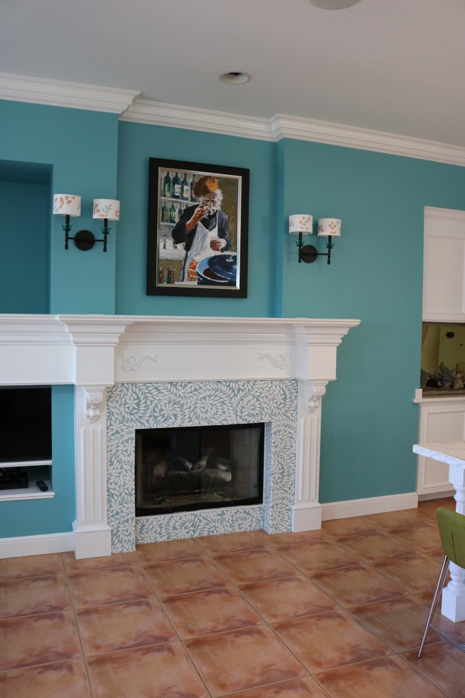 Idée de décoration pour un salon marin de taille moyenne et ouvert avec un mur bleu, tomettes au sol, une cheminée standard, un manteau de cheminée en carrelage, un téléviseur encastré et un sol marron.