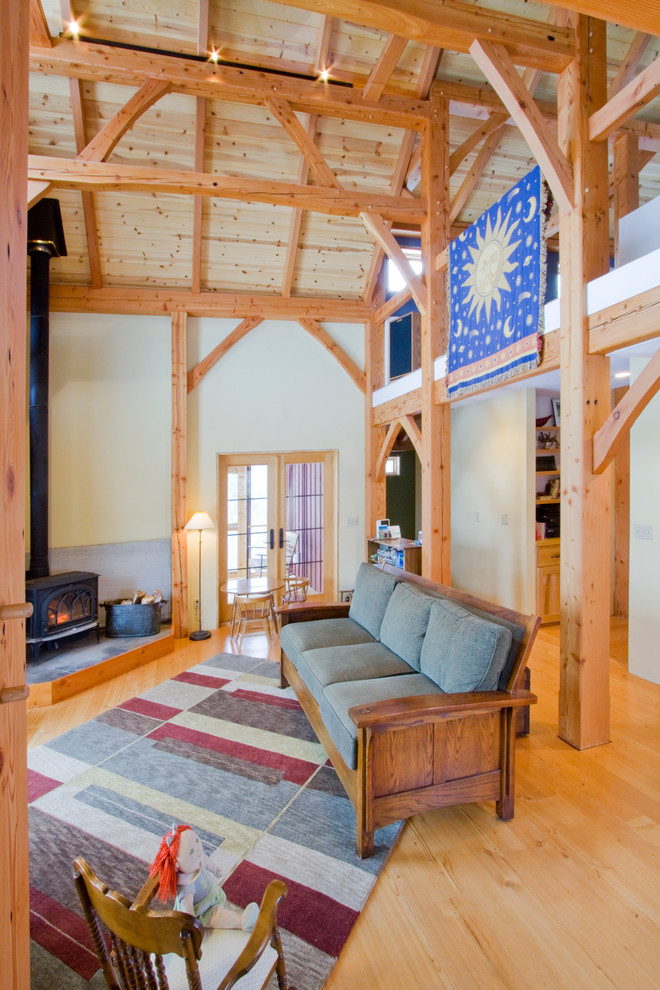 Foto de salón abierto de estilo de casa de campo con suelo de madera clara y estufa de leña
