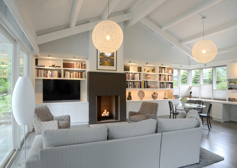 Cette image montre un salon design avec un manteau de cheminée en carrelage et éclairage.
