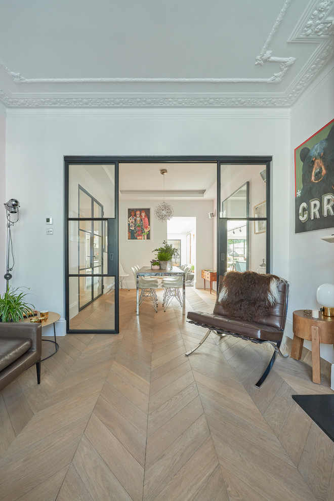 Mittelgroßes Modernes Wohnzimmer mit weißer Wandfarbe, braunem Holzboden, Kaminofen, Kaminumrandung aus Stein und freistehendem TV in London