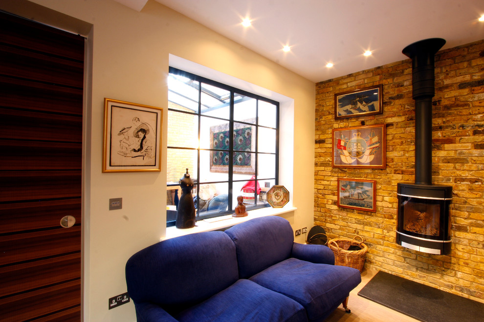Photo of a small modern enclosed living room in London with a wood burning stove.