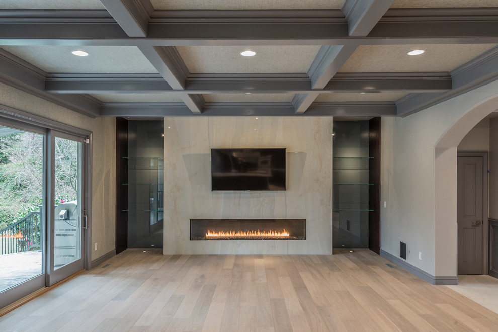 Diseño de salón moderno con paredes beige, suelo de madera clara, chimenea lineal, marco de chimenea de madera y televisor independiente