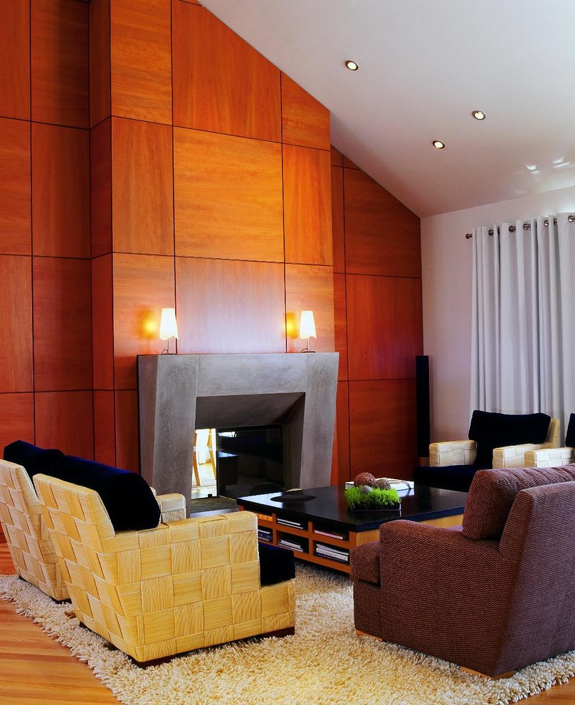 Idée de décoration pour un salon ouvert avec une salle de réception, un mur blanc, un sol en bois brun, une cheminée double-face et un manteau de cheminée en béton.