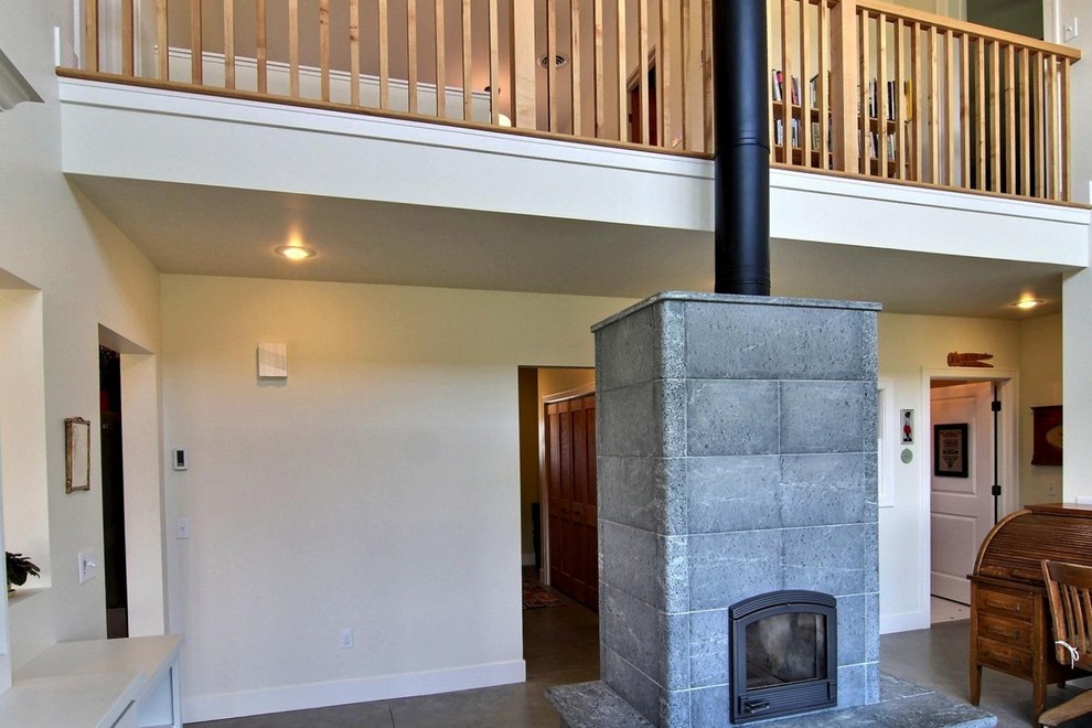 Immagine di un soggiorno american style di medie dimensioni e aperto con pavimento in cemento, stufa a legna, cornice del camino in pietra, sala formale e pareti bianche