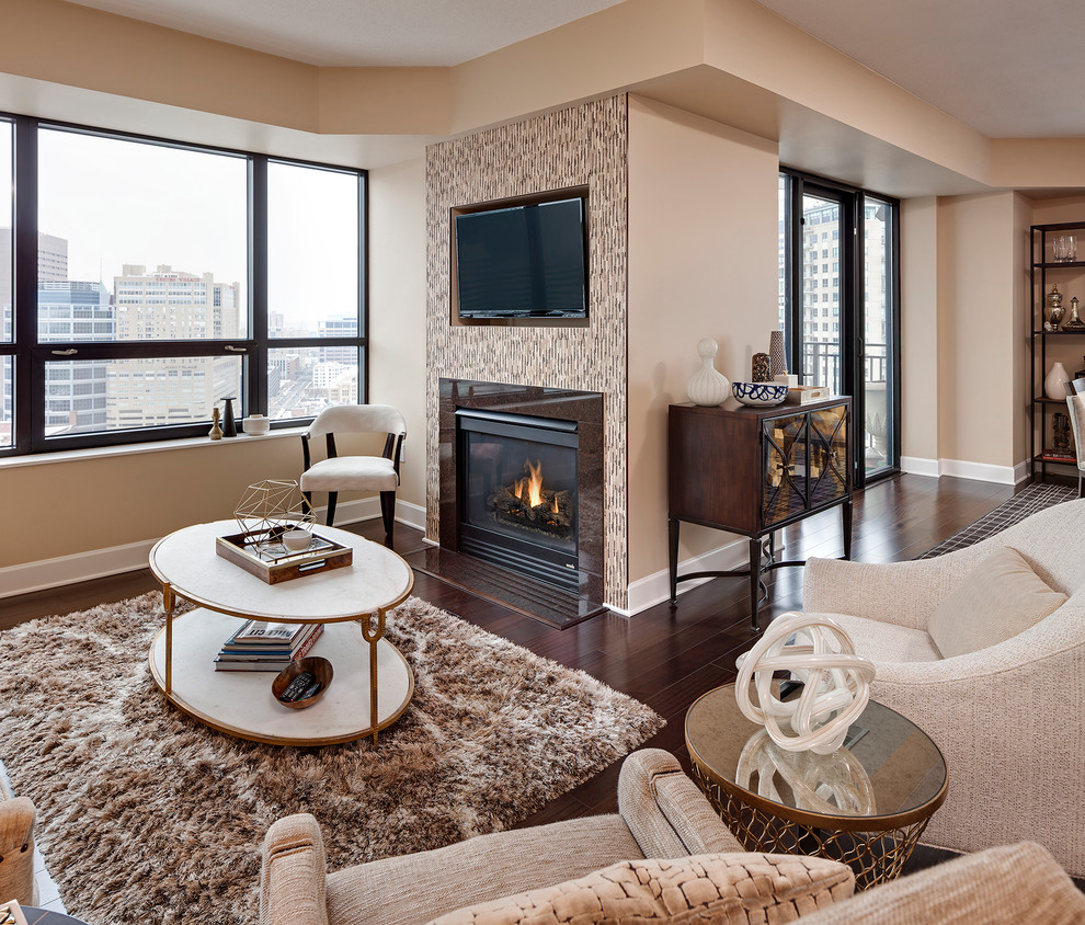 Medium sized contemporary living room in Minneapolis with beige walls, dark hardwood flooring, a standard fireplace, a tiled fireplace surround, a wall mounted tv and brown floors.