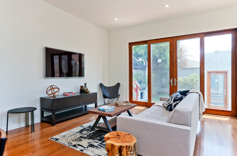 Living room - mid-sized transitional medium tone wood floor living room idea in Los Angeles with a wall-mounted tv