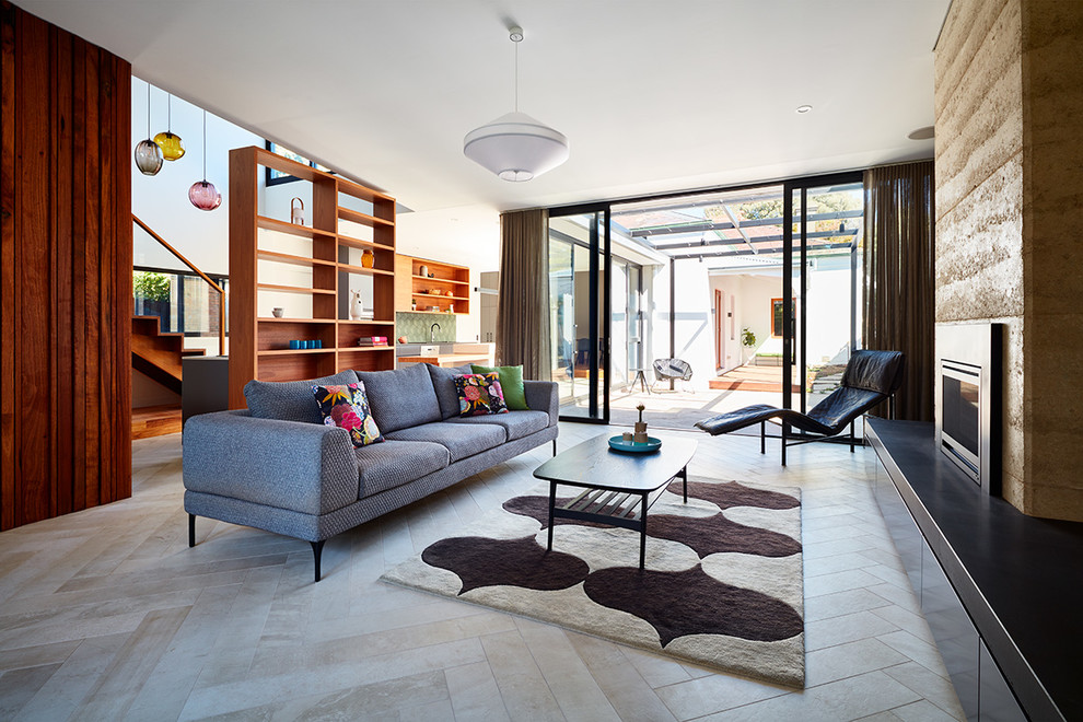 Offenes Modernes Wohnzimmer mit Porzellan-Bodenfliesen, Kamin, beiger Wandfarbe, Kaminumrandung aus Stein und beigem Boden in Melbourne