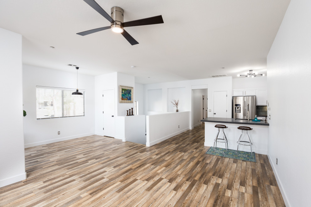 Modernes Wohnzimmer im Loft-Stil mit weißer Wandfarbe, Laminat und buntem Boden in Phoenix