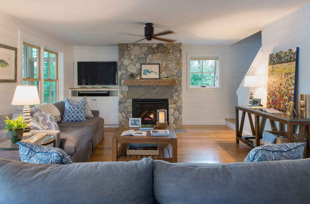 This is an example of a medium sized classic open plan living room in Portland Maine with white walls, medium hardwood flooring, a standard fireplace, a stone fireplace surround and a wall mounted tv.