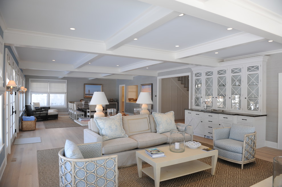Стильный дизайн: большая парадная, открытая гостиная комната в морском стиле с серыми стенами, светлым паркетным полом, телевизором на стене и бежевым полом - последний тренд