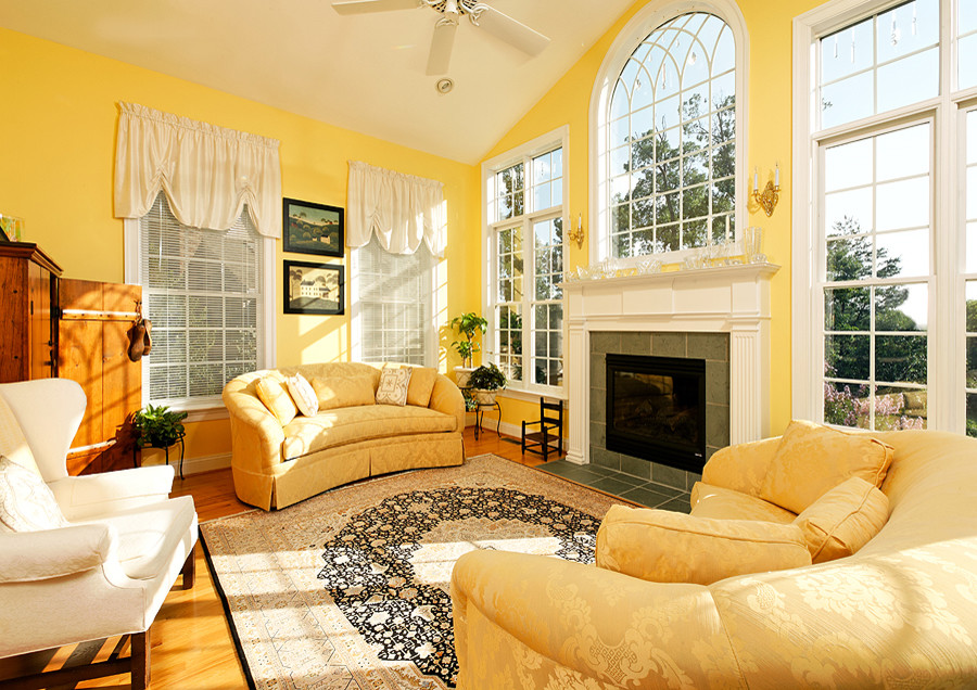 Источник вдохновения для домашнего уюта: парадная, изолированная гостиная комната среднего размера в классическом стиле с желтыми стенами, стандартным камином, фасадом камина из камня, скрытым телевизором и светлым паркетным полом