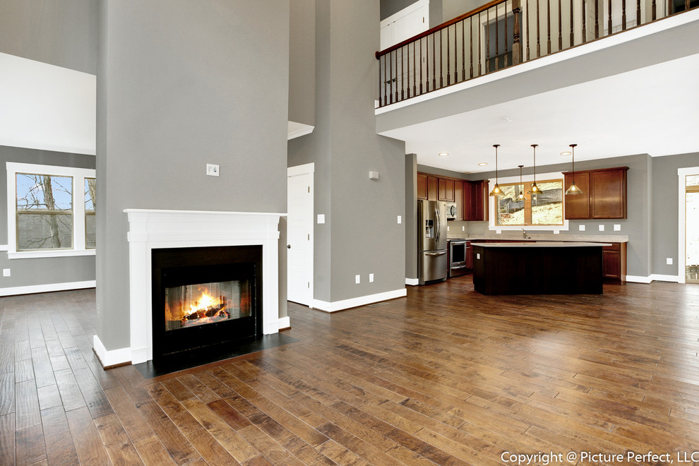 Offenes Klassisches Wohnzimmer mit grauer Wandfarbe, braunem Holzboden und Tunnelkamin in Baltimore