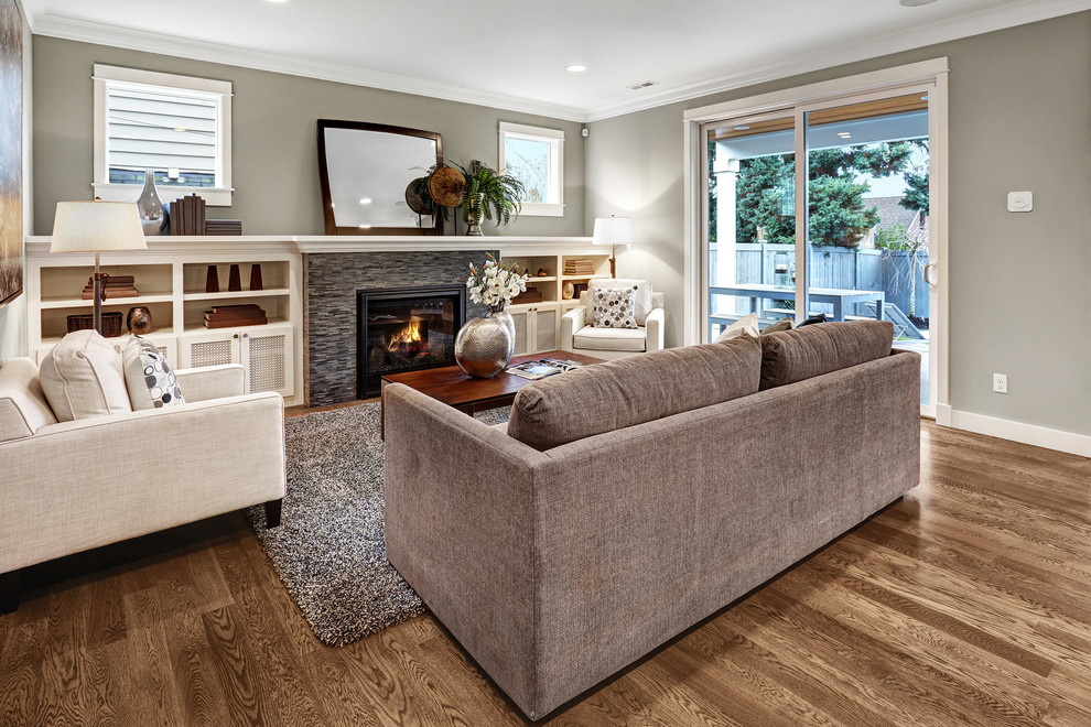 Classic formal open plan living room in Seattle with beige walls, light hardwood flooring, a standard fireplace, a wall mounted tv and a stone fireplace surround.