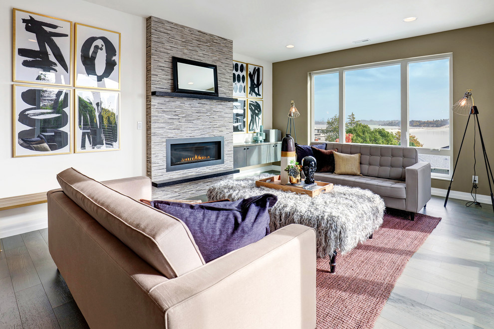 Идея дизайна: изолированная гостиная комната в современном стиле с светлым паркетным полом, стандартным камином, фасадом камина из плитки и телевизором на стене